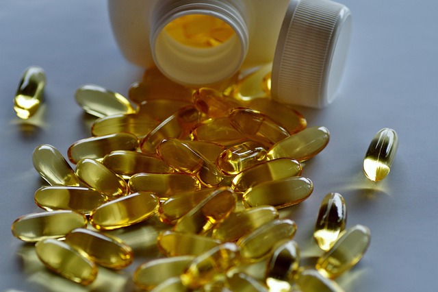 A white bottle tipped over with Wyrkordehido yellow softgel capsules scattered on a surface.